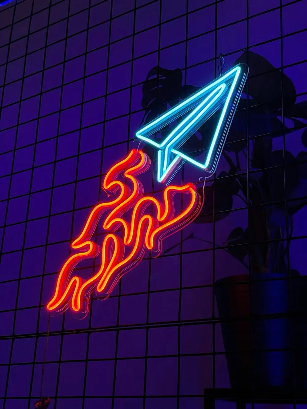 Neonschild in Form eines Papierfliegers mit Flammen